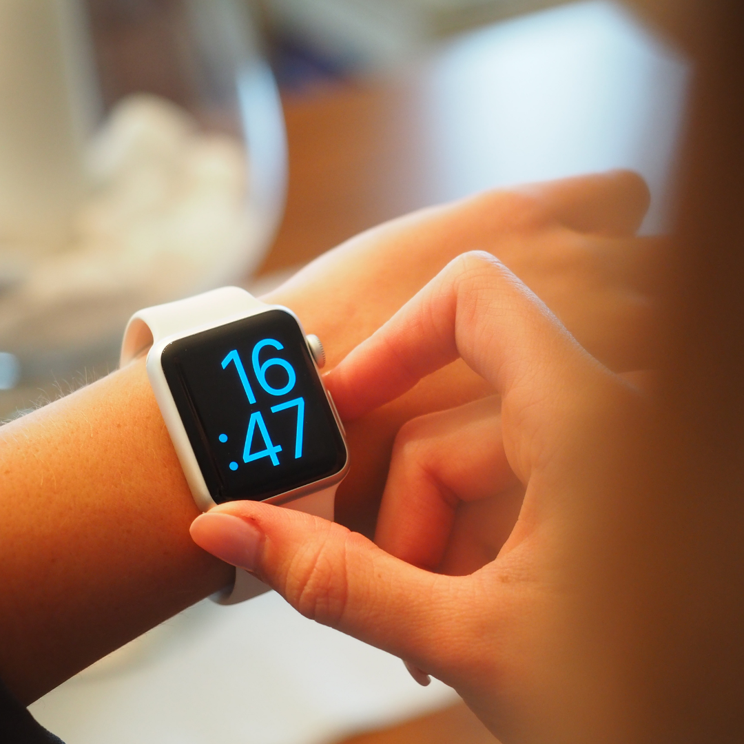 a person pressing buttons on a smart watch on their wrist