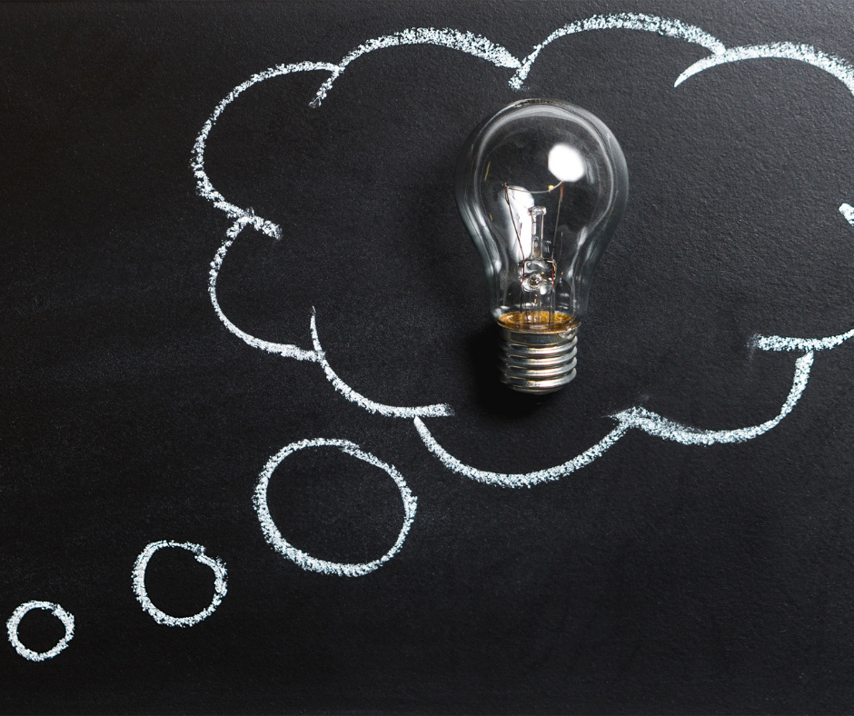 Thought bubble on a chalkboard with a lightbulb inside.